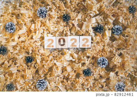 wooden numbers 2022 cubes symbolizng Christmas or new year celebration. pine cones and shavings 82912461