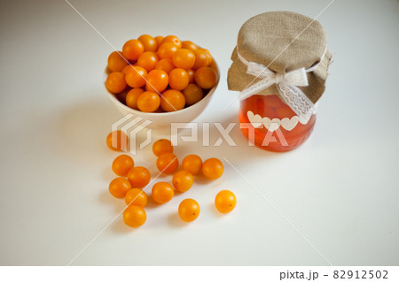 cherry plums yellow Jam, fresh fruits homemade marmalade glass jar on white background 82912502