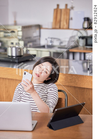 テレワーク中に集中が切れてネットサーフィンする若い女性 テレワーク中に集中が切れてネットサーフィンする若い女性 82912624