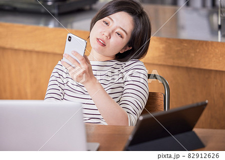 テレワーク中に集中が切れてネットサーフィンする若い女性 テレワーク中に集中が切れてネットサーフィンする若い女性 82912626
