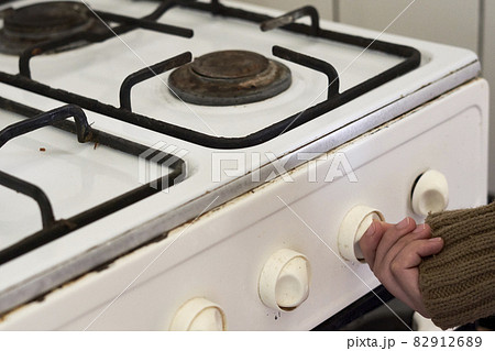 Woman checking gas. Female hand trying to turn on old gas stove. No gas, Winter and cold period concepts. Lack of gas in the pipeline Woman checking gas. Female hand trying to turn on old gas stove. No gas, Winter and cold period concepts. Lack of gas in the pipeline 82912689