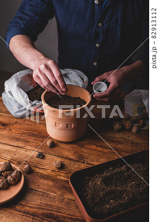 Man Sowing Thyme Seeds into Terracotta Pot Man Sowing Thyme Seeds into Terracotta Pot 82913112