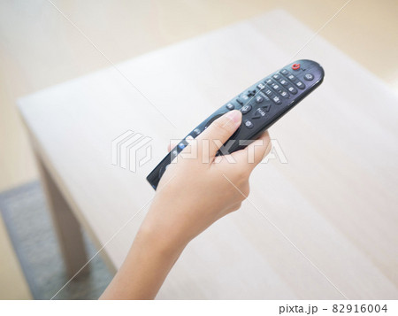 テレビのリモコンを操作する手元　クローズアップイメージ 82916004