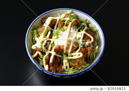 千切りキャベツ、万能ねぎ、温泉卵、からあげ丼を黒背景で俯瞰撮影 82916821
