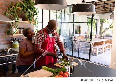 Happy african american senior couple cooking together in kitchen 82918358