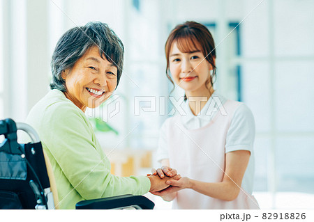 車いすの高齢者と若い介護福祉士 82918826