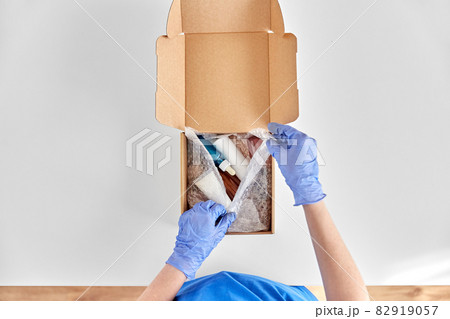 hands in gloves packing parcel box with cosmetics hands in gloves packing parcel box with cosmetics 82919057