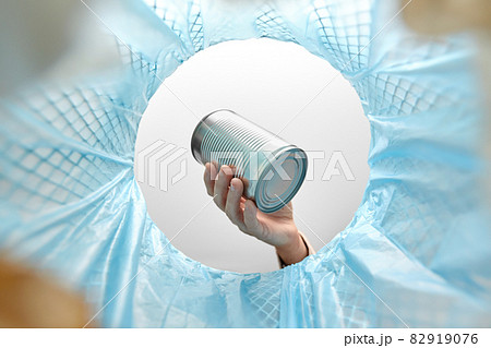hand throwing tin can into rubbish bin hand throwing tin can into rubbish bin 82919076