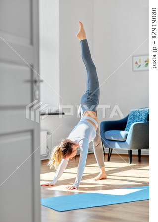 woman doing yoga exercise on window sill at studio 82919080