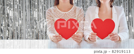 close up of happy lesbian couple with red hearts 82919113