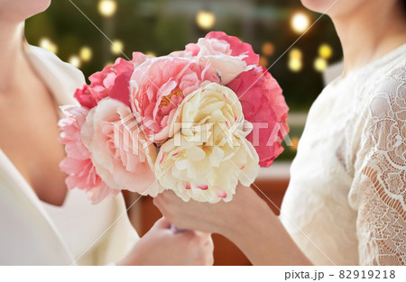 close up of lesbian couple with flowers at party 82919218