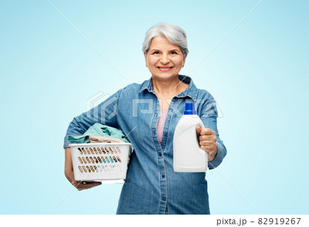 smiling senior woman with laundry basket 82919267