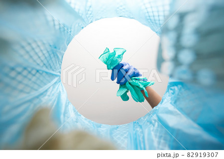 hand throwing used medical gloves into trash can hand throwing used medical gloves into trash can 82919307
