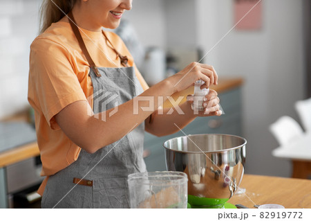 happy young woman cooking food on kitchen at home 82919772