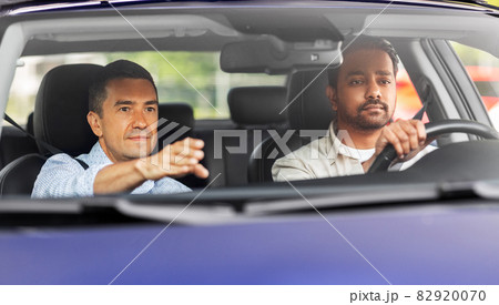 car driving school instructor teaching male driver car driving school instructor teaching male driver 82920070