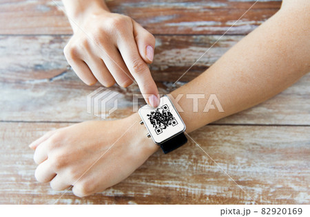 woman's hands with qr code on smart watch 82920169