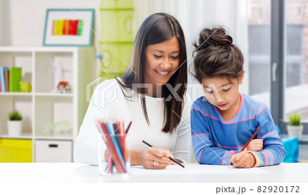 happy mother and daughter drawing at home 82920172