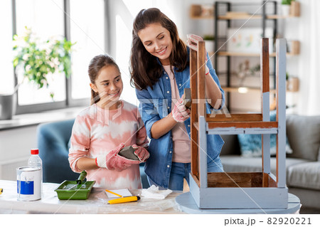 mother and daughter sanding old table with sponge mother and daughter sanding old table with sponge 82920221