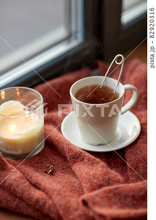 cup of tea and candle on window sill cup of tea and candle on window sill 82920316