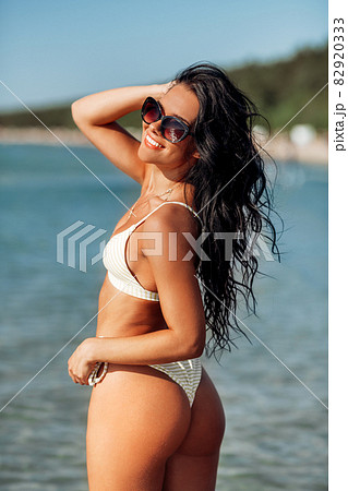 happy young woman in bikini swimsuit on beach happy young woman in bikini swimsuit on beach 82920333