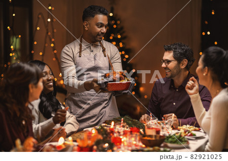 happy friends having christmas dinner at home happy friends having christmas dinner at home 82921025