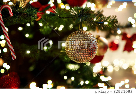 golden christmas ball decoration on fir tree 82921092