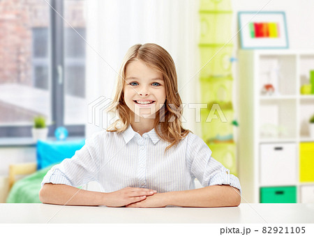 happy smiling student girl sitting at table 82921105