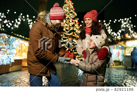 happy family with gift at christmas market in city 82921106
