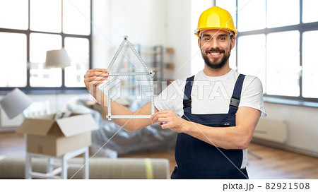 happy male builder with carpenter's rule at home 82921508