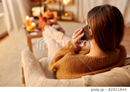 woman calling on smartphone at home on halloween 82921844