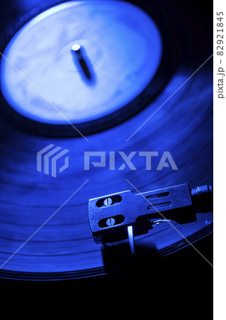Close-up of a record player needle on record in blue light 82921845