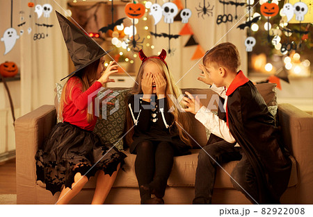 kids in halloween costumes playing at home 82922008