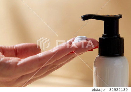 close up of hands with bottle of body lotion close up of hands with bottle of body lotion 82922189