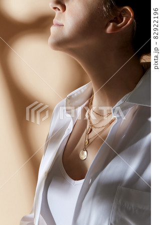 close up of woman with golden jewelry on her neck 82922196
