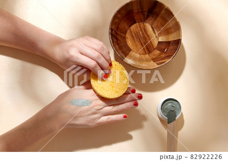 hands applying blue cosmetic clay mask to skin hands applying blue cosmetic clay mask to skin 82922226