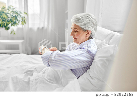 happy senior woman sitting in bed at home bedroom happy senior woman sitting in bed at home bedroom 82922268