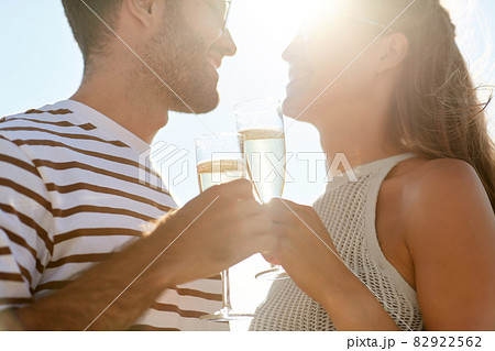 happy couple drinking champagne on summer beach happy couple drinking champagne on summer beach 82922562