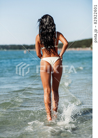 young woman in bikini swimsuit running on beach young woman in bikini swimsuit running on beach 82922601