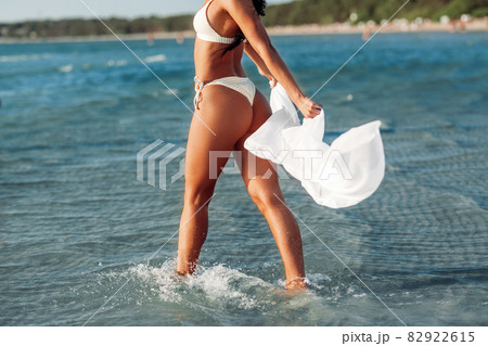 woman in bikini swimsuit with cover-up on beach woman in bikini swimsuit with cover-up on beach 82922615