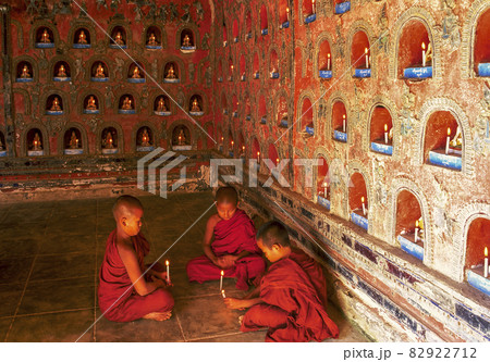 Myanmar, Shan State, Inle Lake, Novice Buddhist monks lighting candles in Shwe Yan Pyay Monastery Myanmar, Shan State, Inle Lake, Novice Buddhist monks lighting candles in Shwe Yan Pyay Monastery 82922712