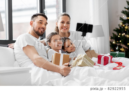 family with christmas gifts taking selfie in bed family with christmas gifts taking selfie in bed 82922955
