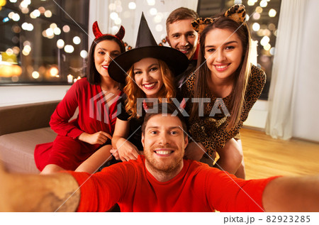 happy friends in halloween costumes taking selfie happy friends in halloween costumes taking selfie 82923285