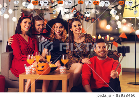 happy friends in halloween costumes taking selfie happy friends in halloween costumes taking selfie 82923460