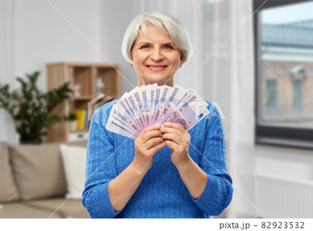 senior woman with hundreds of euro money banknotes senior woman with hundreds of euro money banknotes 82923532