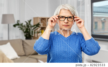 portrait of senior woman in glasses over grey portrait of senior woman in glasses over grey 82923533