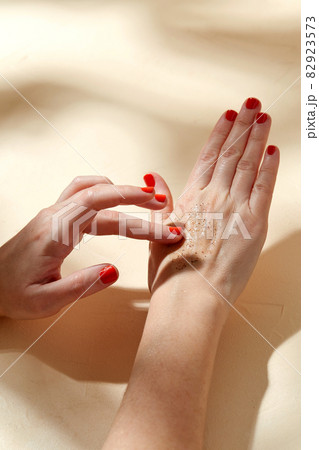 close up of hands applying natural scrub to skin 82923573