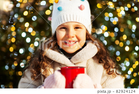 little girl with cup of hot tea in winter park 82924124