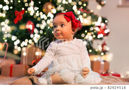 baby girl at christmas tree with gifts at home baby girl at christmas tree with gifts at home 82924518