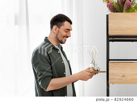 man placing aroma reed diffuser to shelf home 82924660