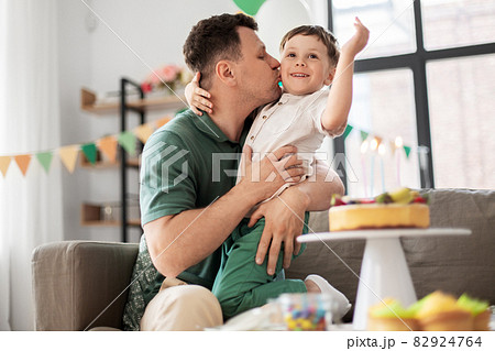father kissing little son at home birthday party father kissing little son at home birthday party 82924764